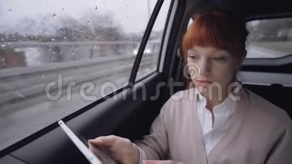 女人用平板电脑透过窗户看视频的预览图