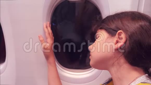 航空飞机概念年轻的女孩看着坐在窗边的飞机生活方式之夜的航班视频的预览图
