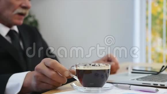 商人在看手提电脑屏幕时喝咖啡视频的预览图