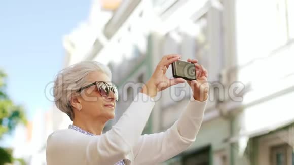 城市中使用智能手机拍照的高级女性视频的预览图