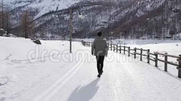 一个英俊自信的人在雪地里行走视频的预览图