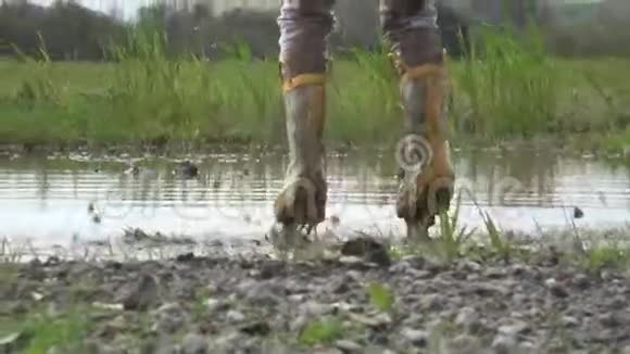 穿雨靴的孩子在水坑里快乐地跳跃视频的预览图