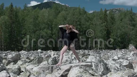 女孩在岩石上做瑜伽视频的预览图