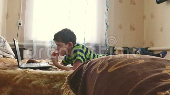 男孩正在玩手提电脑上网视频的预览图