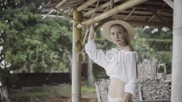 美丽自然的女人穿着波霍风格的时尚穿着白色衬衫比基尼和帽子在一个美丽的夏天视频的预览图