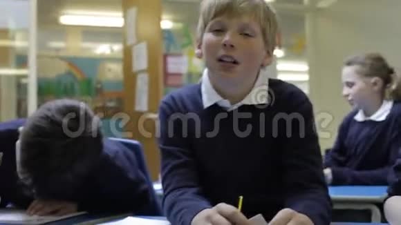 教师帮助学生在餐桌上工作视频的预览图