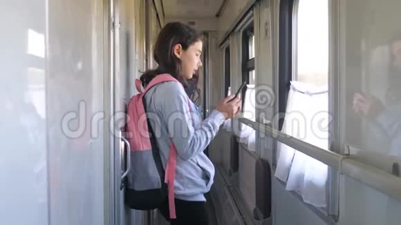 小女孩走在火车车厢生活方式车上背包和智能手机旅游运输铁路视频的预览图