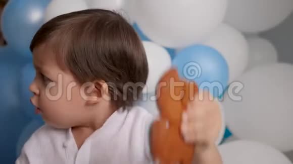 两岁的男孩带着一辆车吃一个喜庆的蓝色蛋糕视频的预览图
