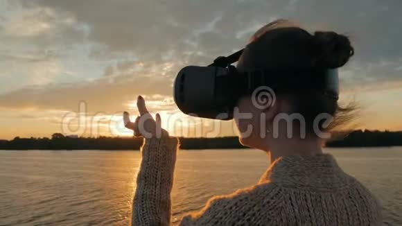 日落时分在游轮甲板上戴虚拟现实眼镜的女人视频的预览图