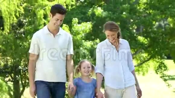 快乐的父母和他们的小女孩在公园视频的预览图