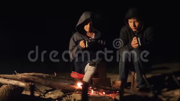 孩子们微笑孩子们喝茶青少年坐在篝火旁旅行徒步旅行冒险露营冒险野营视频的预览图