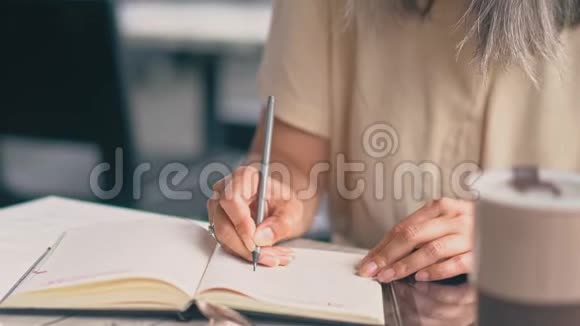 女人写在笔记本上视频的预览图