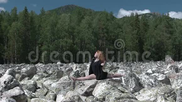 女孩在岩石上做瑜伽视频的预览图