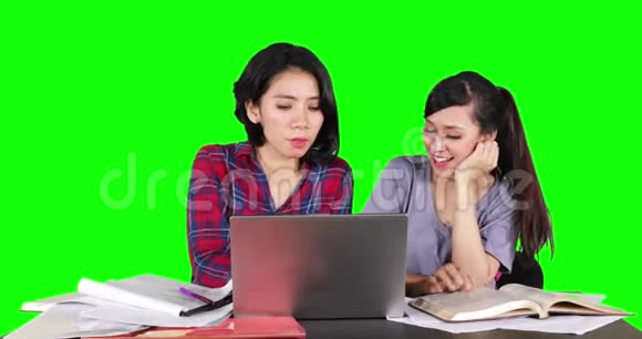 两个学生在使用笔记本电脑学习视频的预览图