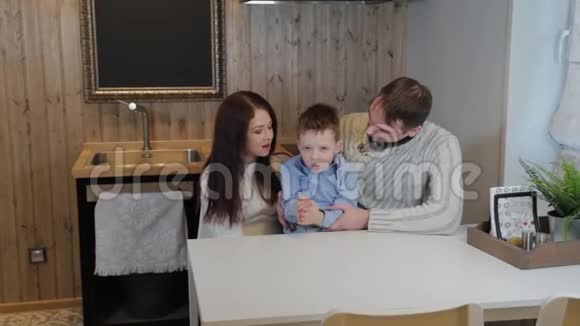 幸福的家庭和一个孩子在厨房的现代内部视频的预览图
