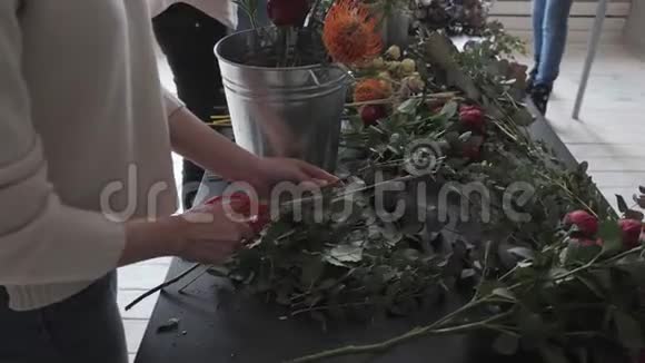 主班女花艺师在工作与束花女孩制作各种秋花的花束商务视频的预览图