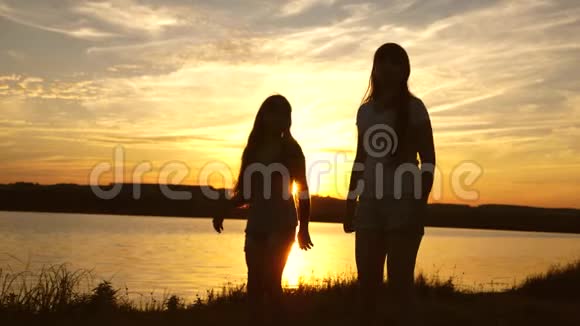 年轻人的女朋友在日落时度假迪斯科湖边聚会孩子们跳舞快乐的女孩在海滩上跳舞视频的预览图