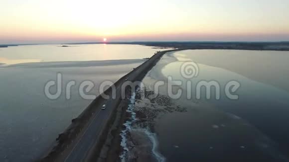 4K早春日落时分在水中飞越公路空中飞行视频的预览图