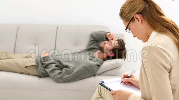 躺在沙发上和他的治疗师说话的年轻人视频的预览图