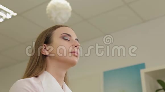 专业的化妆师给美容院的客户蒙上了眼影视频的预览图