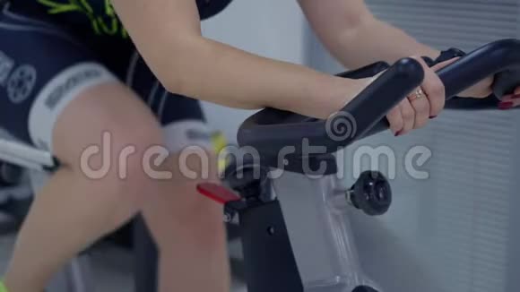 运动女性在健身俱乐部健身运动时锻炼自行车视频的预览图