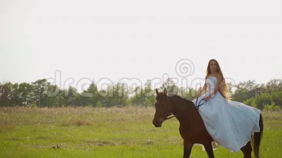 新娘骑马穿着白色连衣裙的女孩在田野里骑着马视频的预览图