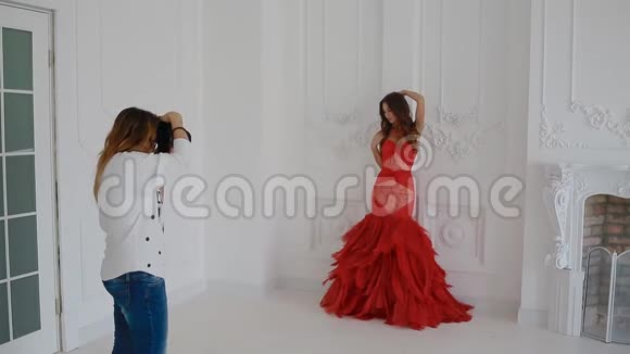 一个穿着红色裙子在工作室摆姿势的女强人视频的预览图