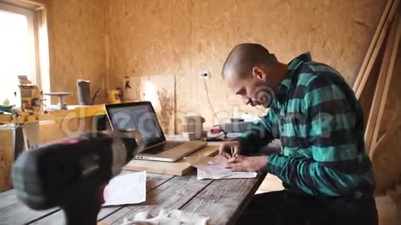 年轻的木匠在他的车间里画胡子视频的预览图