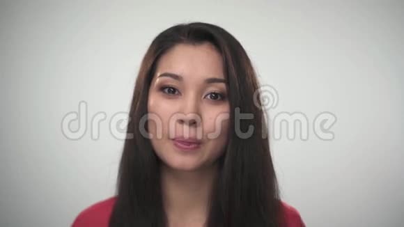 美丽年轻的亚洲女人对着镜头微笑的肖像特写肖像视频的预览图