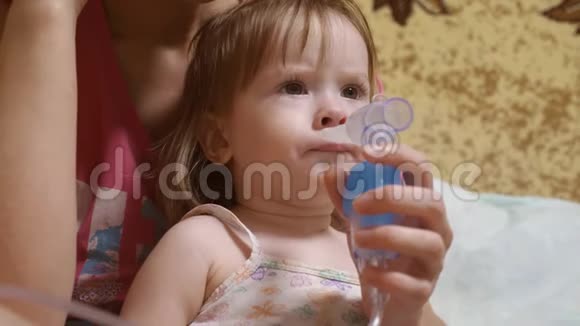 孩子生病了通过吸入器呼吸幼儿通过吸入吸入蒸气治疗流感小女孩被对待视频的预览图