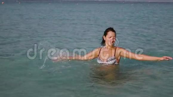 在美丽的日出上玩海水的女人视频的预览图