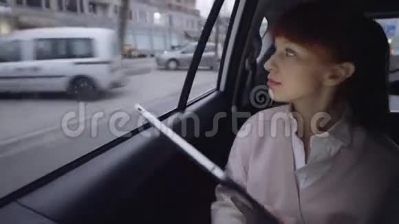 女人在使用平板电脑时透过窗户视频的预览图