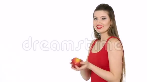 女人拿着红苹果在白色背景下微笑视频的预览图