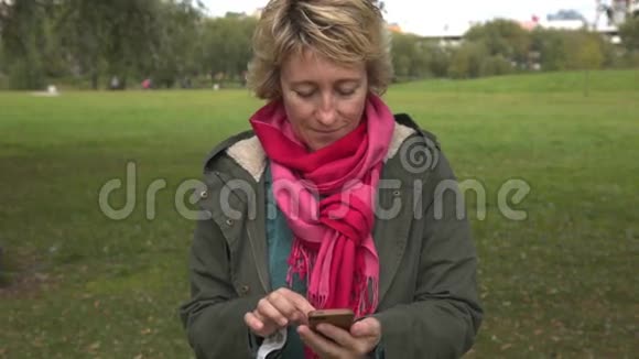 公园里使用智能手机的成年女性视频的预览图