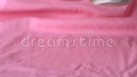 婴儿鞋落在粉红色的毯子上视频的预览图