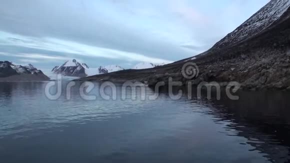 白海熊在斯瓦尔巴特岛荒凉的冰原上的岩石海岸上视频的预览图