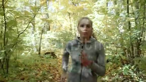 一个女孩在公园里跑步那个女孩穿过秋天的公园视频的预览图