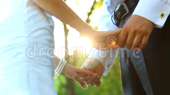 一对年轻夫妇牵着手站在公园里视频的预览图
