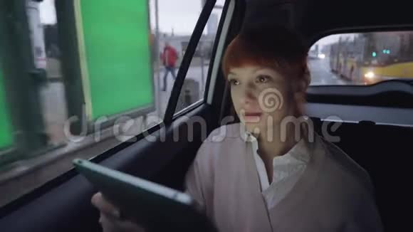 女人透过窗户用平板电脑视频的预览图