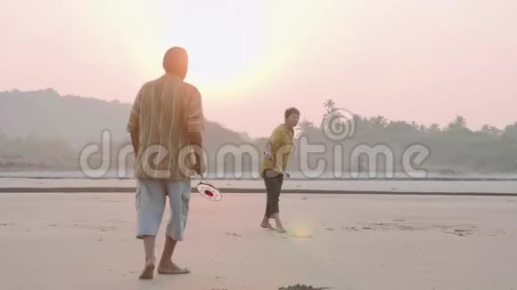 活跃的老夫妇在海滩上打太极圆球视频的预览图