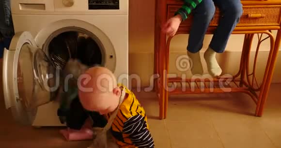 父母购买新型号最新一代洗衣机孩子们试着打开洗衣机洗一些衣服视频的预览图