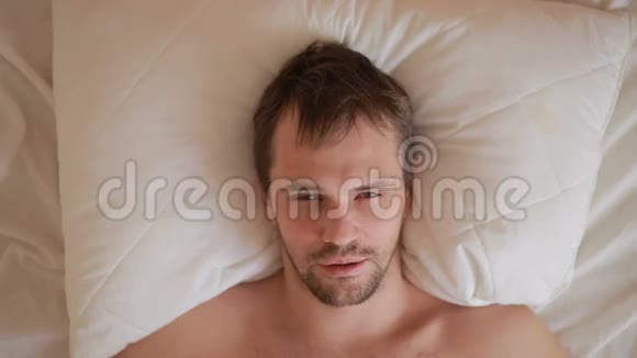 一个发烧的男人躺在家里的床上视频的预览图