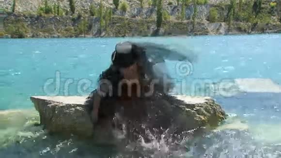 黑色的女人在湖上泼水视频的预览图