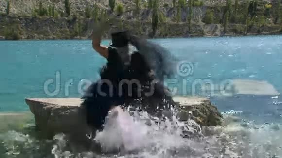 穿黑衣服的女人在池塘里泼水视频的预览图