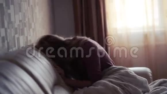 沮丧的女人在床上在沙发上哭泣的女孩视频的预览图