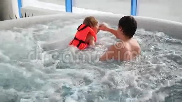 男人用按摩浴缸给快乐的宝宝洗澡视频的预览图