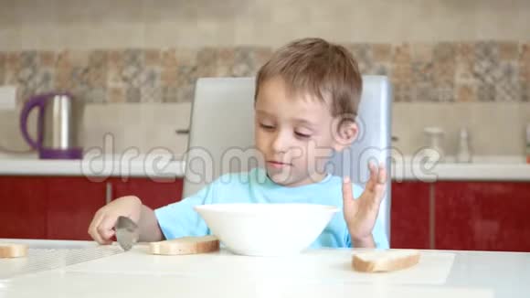 孩子坐在厨房的桌子上吃汤视频的预览图
