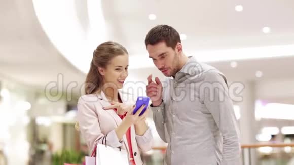 带着智能手机和购物包的情侣视频的预览图