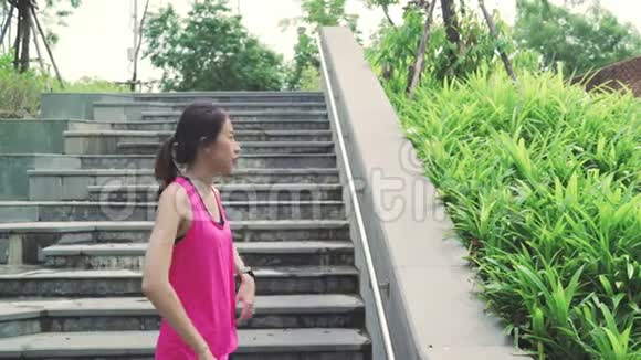 健康美丽的年轻亚洲运动女性穿着运动服装双腿发暖伸展双臂准备上街跑步视频的预览图