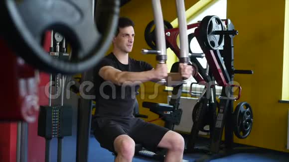 一个有运动身材的人在健身房的模拟器里做运动视频的预览图